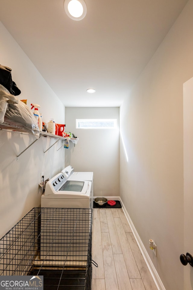 clothes washing area with wood-type flooring and washer and dryer