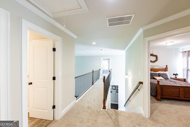 hall with crown molding and light colored carpet