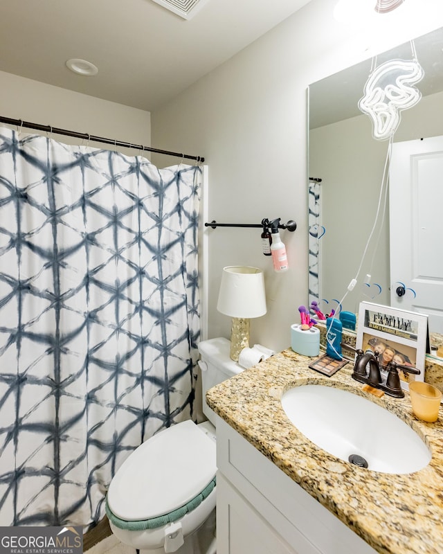 bathroom featuring vanity and toilet