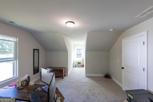 office space featuring light colored carpet and vaulted ceiling