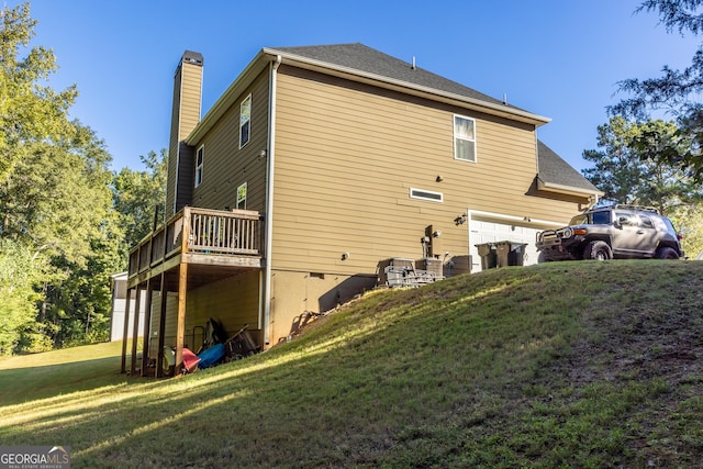 view of home's exterior with a garage, a wooden deck, and a lawn