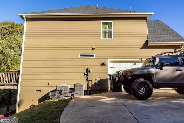 back of house with cooling unit and a garage