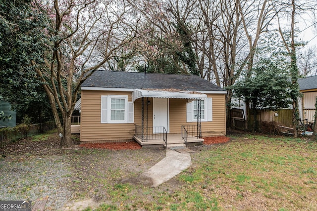 bungalow with a front yard and fence