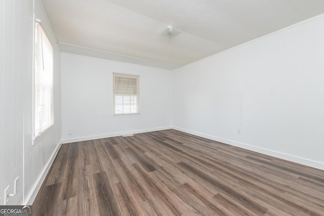 spare room featuring dark wood-style flooring and baseboards