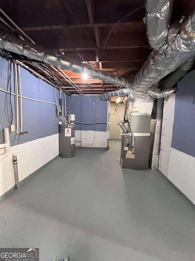 basement featuring electric water heater and heating unit