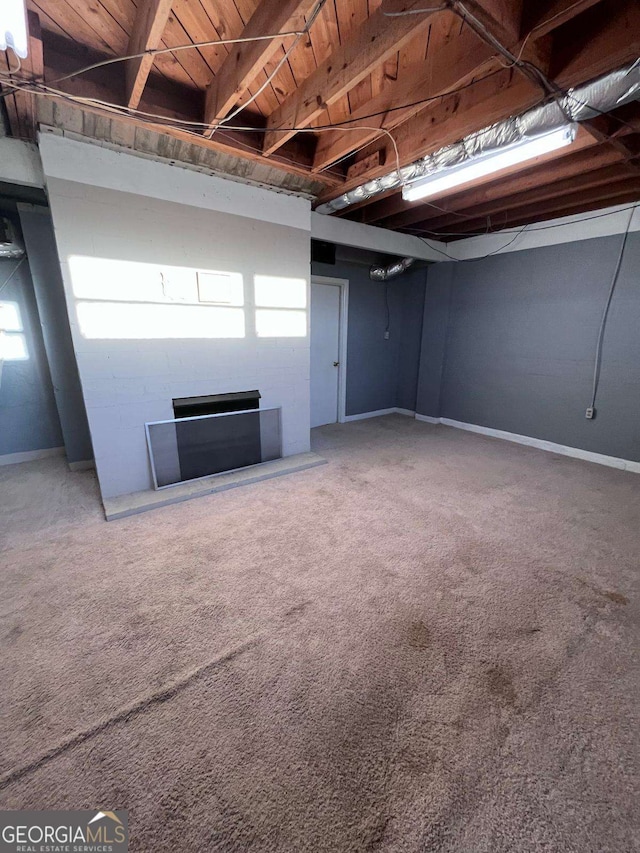 basement with a fireplace and carpet