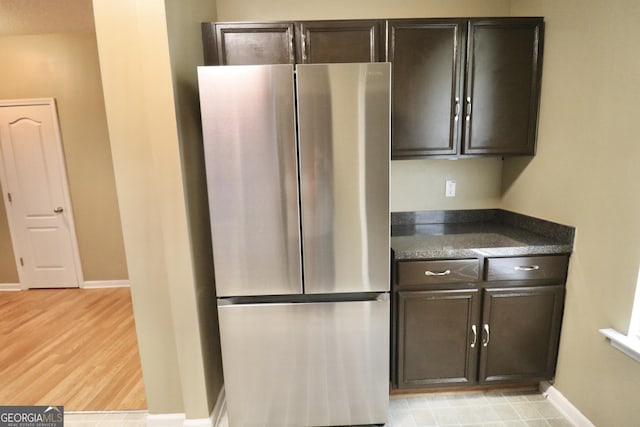 kitchen featuring stainless steel refrigerator, dark brown cabinetry, and light hardwood / wood-style floors