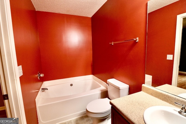 bathroom featuring vanity, a bathtub, a textured ceiling, and toilet