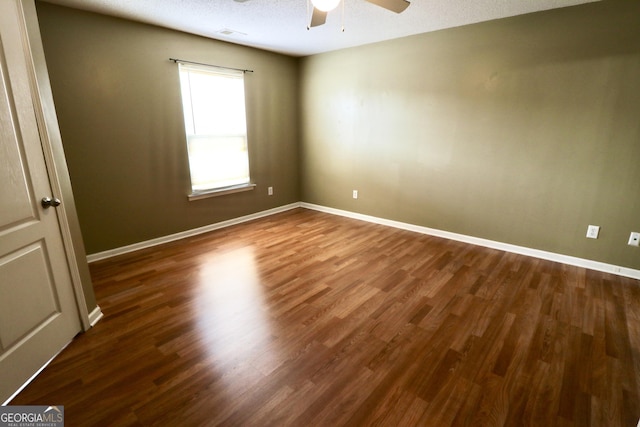 spare room featuring dark hardwood / wood-style floors, a textured ceiling, and ceiling fan