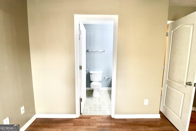 bathroom featuring hardwood / wood-style flooring and toilet