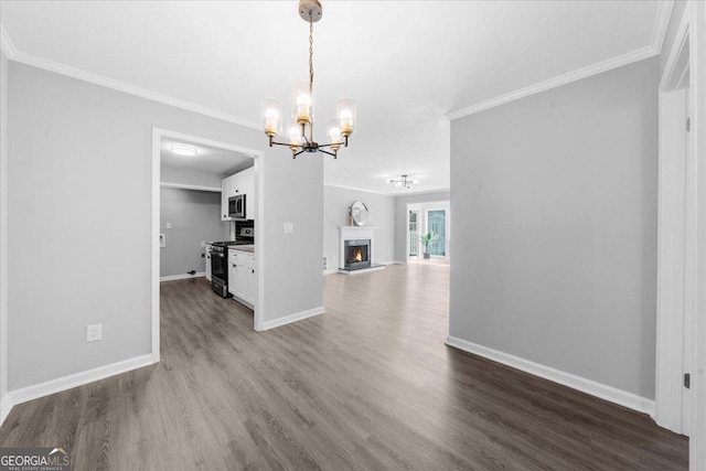 unfurnished living room with crown molding, hardwood / wood-style floors, and an inviting chandelier