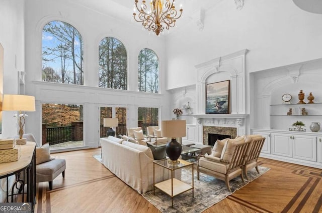 interior space featuring a premium fireplace, a wealth of natural light, built in features, and light hardwood / wood-style floors