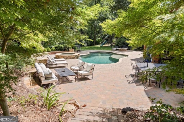 view of pool with a patio area, an outdoor fire pit, and an in ground hot tub