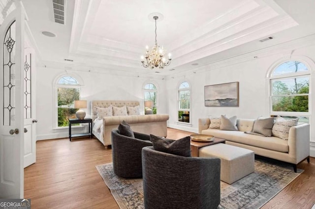 interior space with crown molding, wood-type flooring, and a tray ceiling