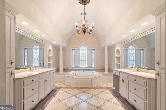 bathroom featuring a bath, built in shelves, vaulted ceiling, and decorative columns