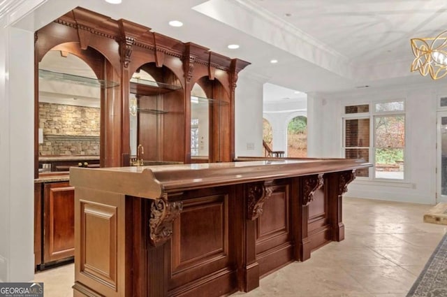 bar featuring ornamental molding and a raised ceiling