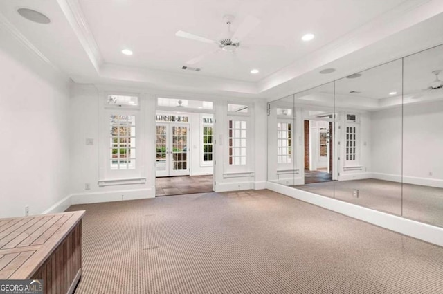 interior space with crown molding, ceiling fan, a tray ceiling, carpet floors, and french doors