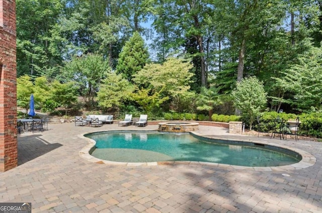 view of pool featuring a patio area and an in ground hot tub