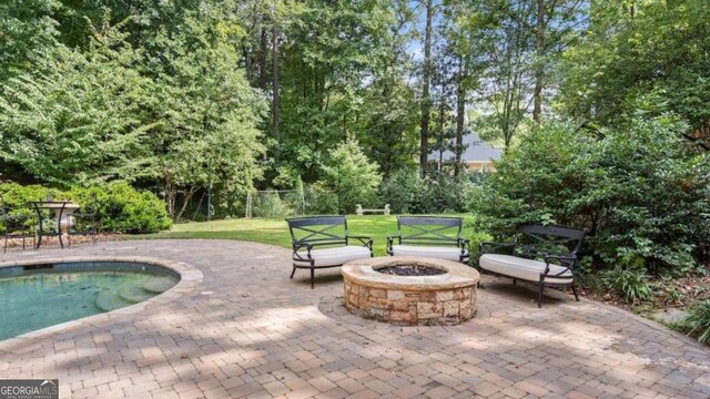 view of pool featuring a yard, a patio area, and a fire pit