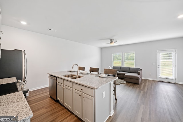 kitchen with appliances with stainless steel finishes, sink, a breakfast bar area, and a center island with sink