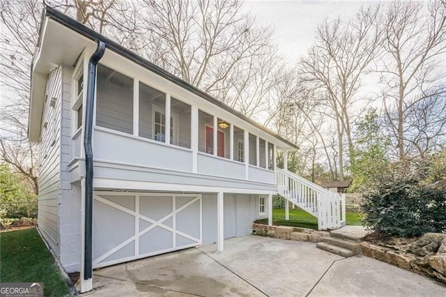 exterior space with a garage and a sunroom