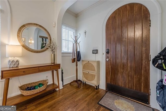 entryway featuring dark wood-type flooring and crown molding