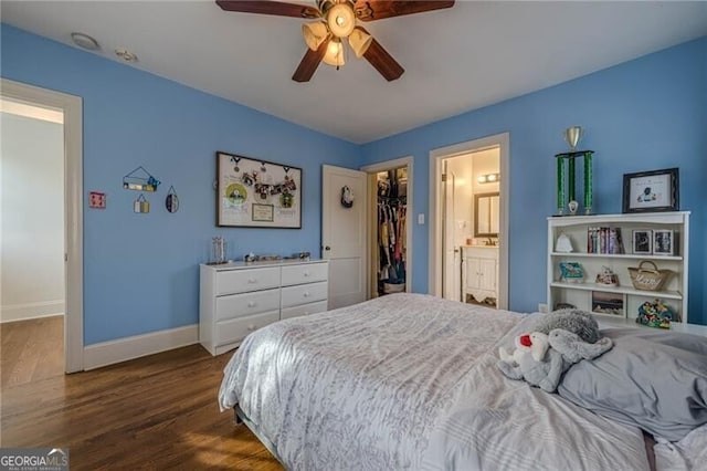 bedroom with dark hardwood / wood-style floors, a walk in closet, ceiling fan, ensuite bath, and a closet