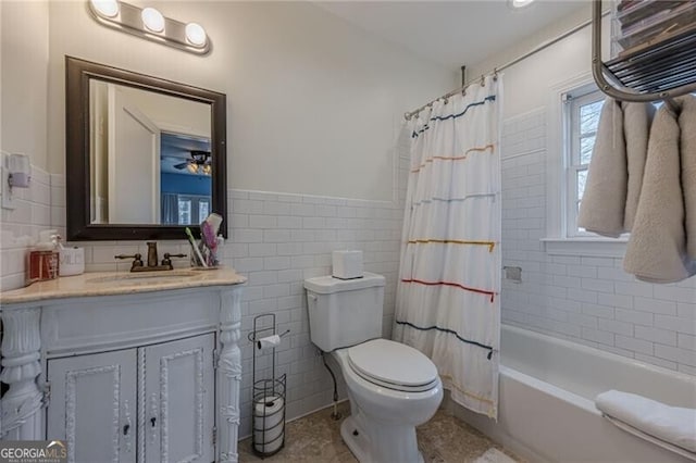 full bathroom featuring toilet, tile walls, vanity, shower / bath combo with shower curtain, and tile patterned flooring