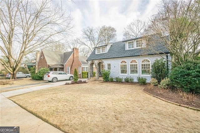 cape cod-style house featuring a front lawn