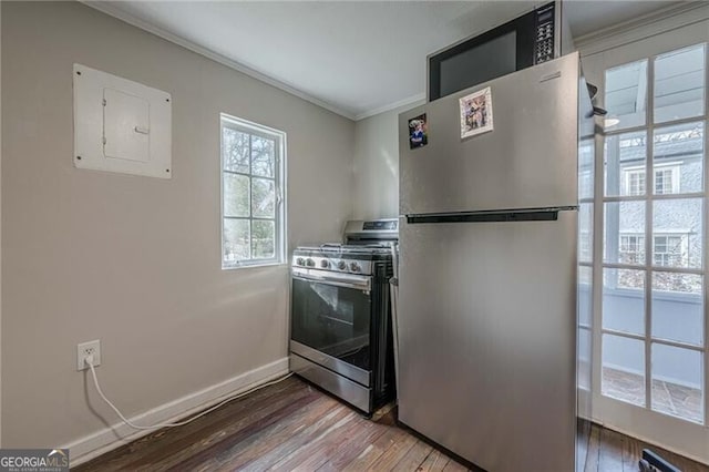 kitchen with hardwood / wood-style floors, ornamental molding, electric panel, and appliances with stainless steel finishes