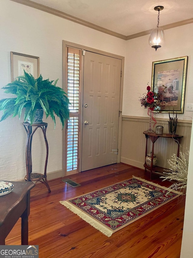 foyer entrance featuring ornamental molding and wood-type flooring