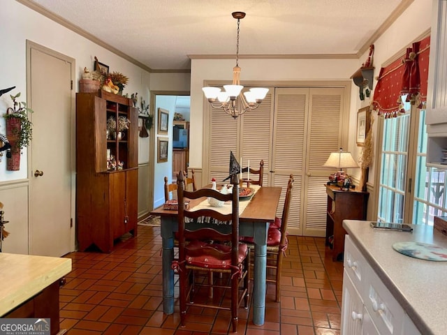 dining space featuring crown molding, a textured ceiling, and a chandelier