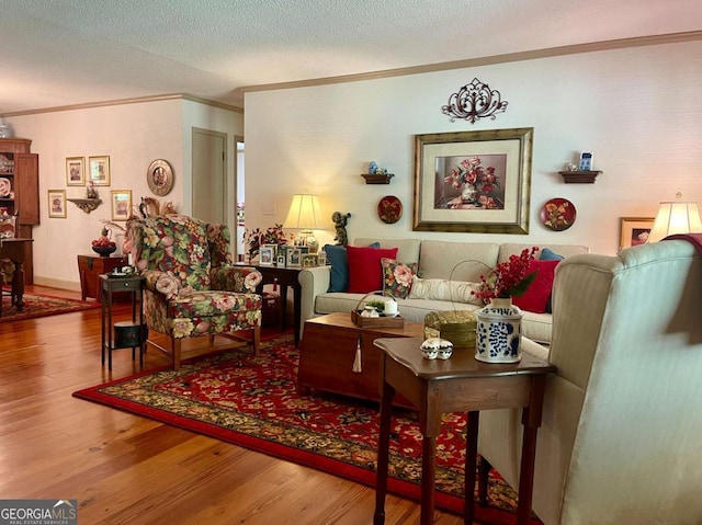 living room featuring crown molding, wood-type flooring, and a textured ceiling