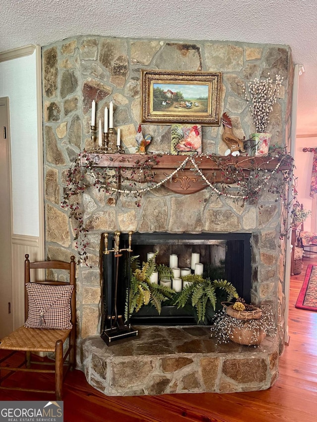 interior details with wood-type flooring, a textured ceiling, and a fireplace