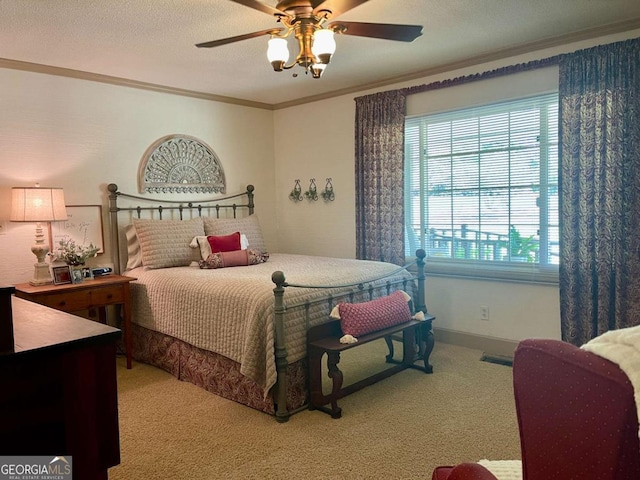 carpeted bedroom featuring ceiling fan, ornamental molding, and a textured ceiling