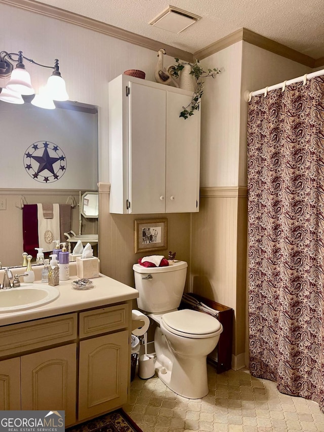 bathroom with vanity, crown molding, toilet, and a textured ceiling