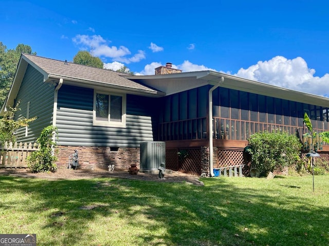 rear view of property with a yard and a sunroom