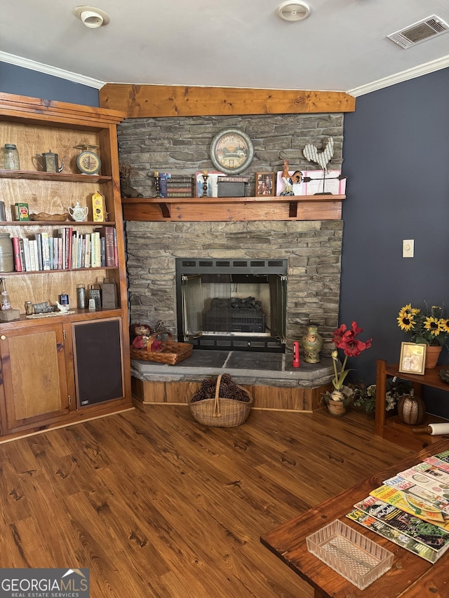 living room with a fireplace, crown molding, and wood-type flooring