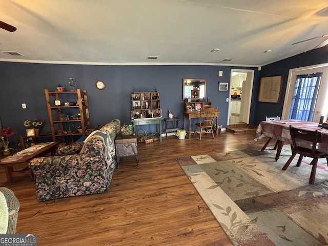 living room with hardwood / wood-style flooring, vaulted ceiling, ornamental molding, and ceiling fan