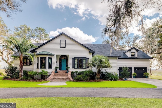 view of front facade with an attached garage, aphalt driveway, a front yard, and a shingled roof