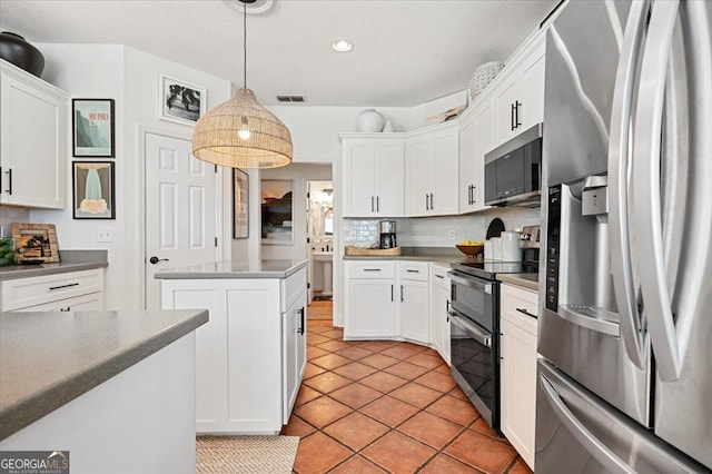 kitchen with visible vents, white cabinets, hanging light fixtures, appliances with stainless steel finishes, and tasteful backsplash