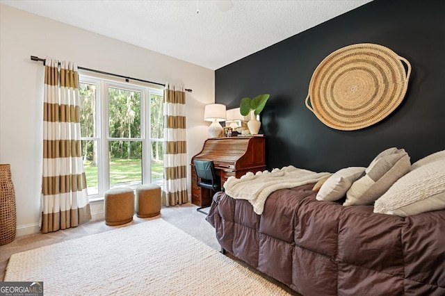 bedroom with light carpet, an accent wall, and multiple windows