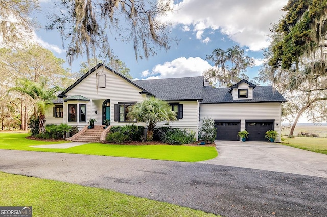 view of front of property featuring a shingled roof, a front yard, driveway, and an attached garage