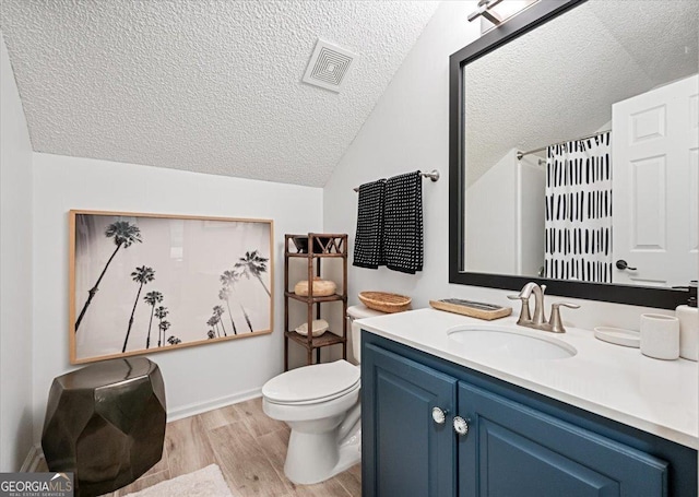 full bath with visible vents, toilet, wood finished floors, a textured ceiling, and vanity