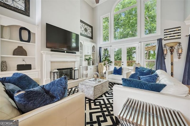 living room featuring french doors, built in features, and a towering ceiling