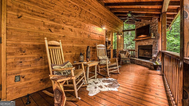 deck with ceiling fan and an outdoor stone fireplace