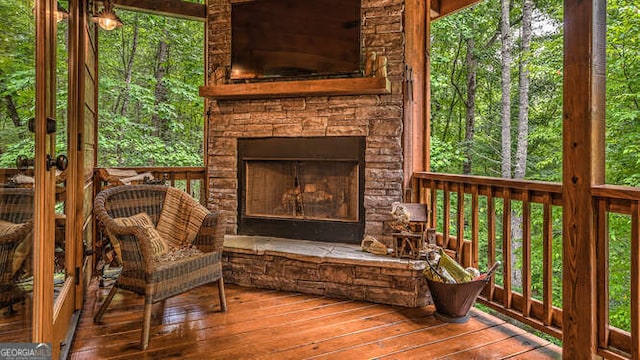 wooden terrace with an outdoor stone fireplace