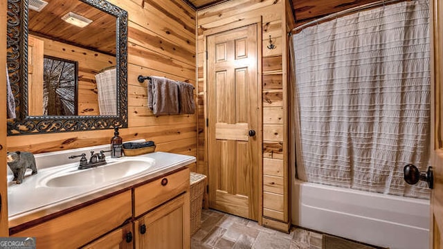 bathroom featuring vanity, shower / bath combination with curtain, and wood walls