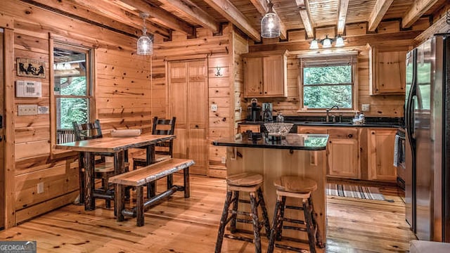 kitchen with stainless steel fridge, wooden walls, sink, and wooden ceiling