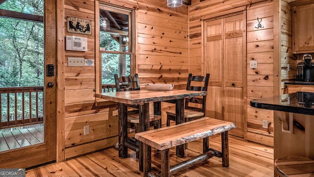 dining space featuring wooden walls and light hardwood / wood-style floors